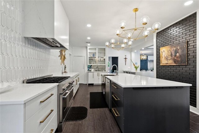 1201 N General Pershing St, Hammond, LA 70401 - kitchen with stainless steel appliances, premium range hood, a chandelier, backsplash, and dark wood-style flooring