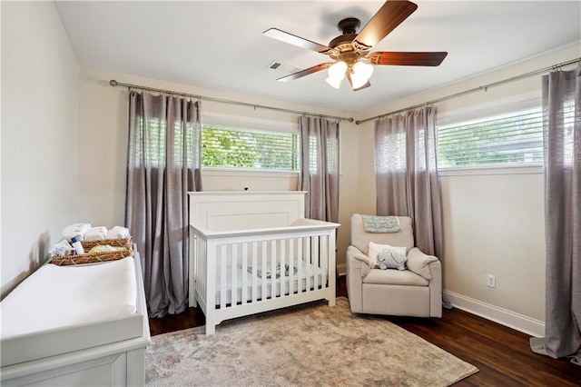 5835 Chamberlain Dr, New Orleans, LA 70122 - bedroom featuring multiple windows, a crib, wood finished floors, and baseboards