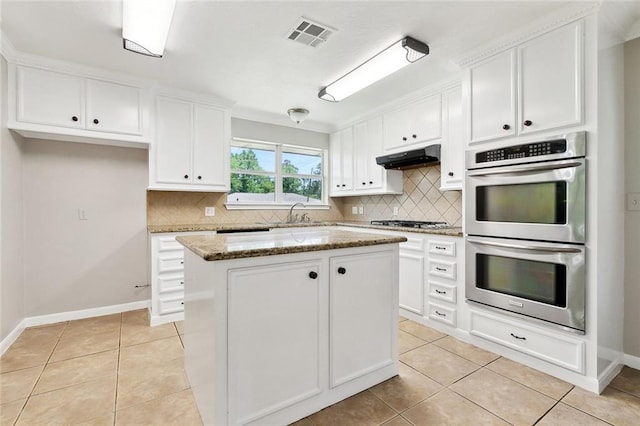 409 Markham Dr, Slidell, LA 70458 - kitchen with stainless steel appliances, light tile patterned floors, tasteful backsplash, and white cabinetry