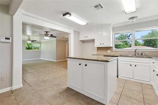 409 Markham Dr, Slidell, LA 70458 - kitchen with a sink, dark stone countertops, crown molding, decorative backsplash, and white cabinetry