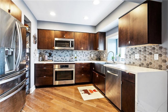 3000 Saint Charles Ave Unit 408, New Orleans, LA 70115 - kitchen with stainless steel appliances, light wood-type flooring, light countertops, dark brown cabinetry, and decorative backsplash