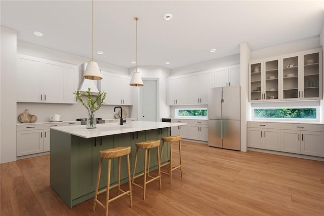 82188 Charles Kelly Rd, Bush, LA 70431 - kitchen featuring stainless steel fridge, light wood finished floors, a breakfast bar, light countertops, and white cabinetry