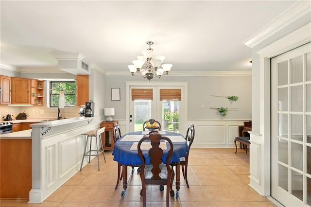 6200 Morton St, Metairie, LA 70003 - dining area featuring french doors, a chandelier, a decorative wall, ornamental molding, and light tile patterned floors