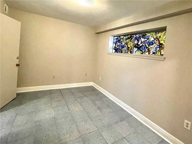 222 London Ave Unit 106, Metairie, LA 70005 - empty room featuring dark tile patterned flooring, baseboards, and a textured ceiling