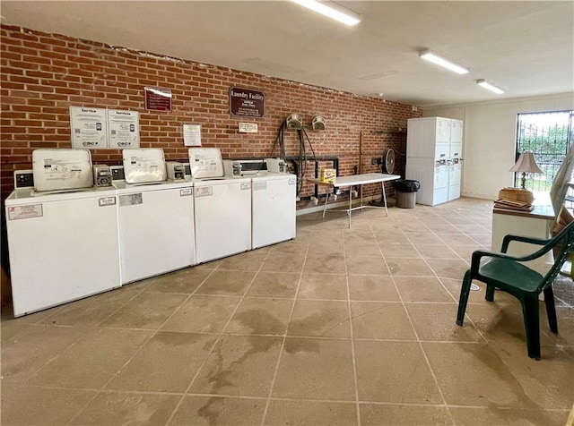 222 London Ave Unit 106, Metairie, LA 70005 - communal laundry room with washer / dryer, brick wall, and light tile patterned floors
