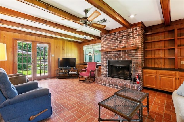 16 Ravan Ave, Harahan, LA 70123 - living area featuring beam ceiling, brick flooring, wood walls, a brick fireplace, and ceiling fan
