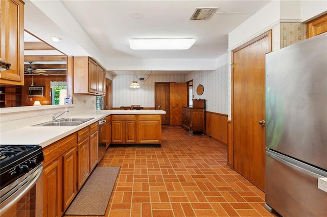 16 Ravan Ave, Harahan, LA 70123 - kitchen with stainless steel appliances, wallpapered walls, a sink, brick patterned floors, and light countertops