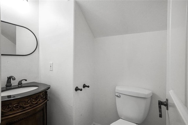 60 Bleu Lake Dr, Covington, LA 70435 - bathroom featuring vanity, vaulted ceiling, and toilet