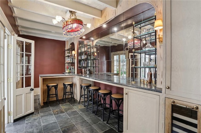 532-38 Governor Nicholls St, New Orleans, LA 70116 - indoor wet bar featuring stone finish floors, wine cooler, and beamed ceiling