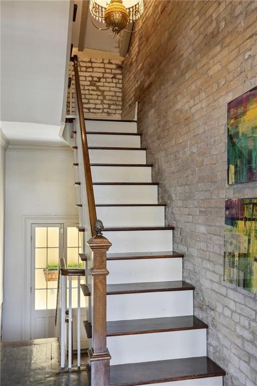 532-38 Governor Nicholls St, New Orleans, LA 70116 - stairs featuring a towering ceiling, a chandelier, brick wall, and crown molding