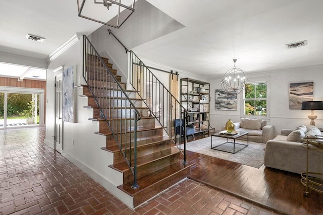 4 Riverdale Dr, Covington, LA 70433 - stairs with ornamental molding, a chandelier, and brick floors