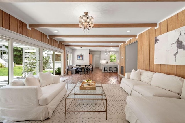 4 Riverdale Dr, Covington, LA 70433 - living room featuring a chandelier, beam ceiling, and wood walls