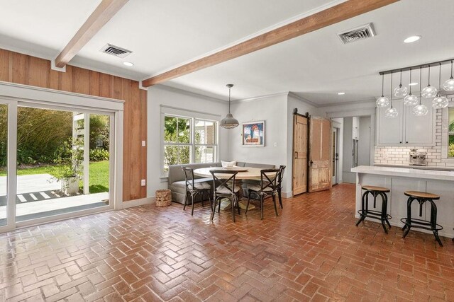 4 Riverdale Dr, Covington, LA 70433 - dining area with beamed ceiling, brick flooring, a barn door, wooden walls, and recessed lighting