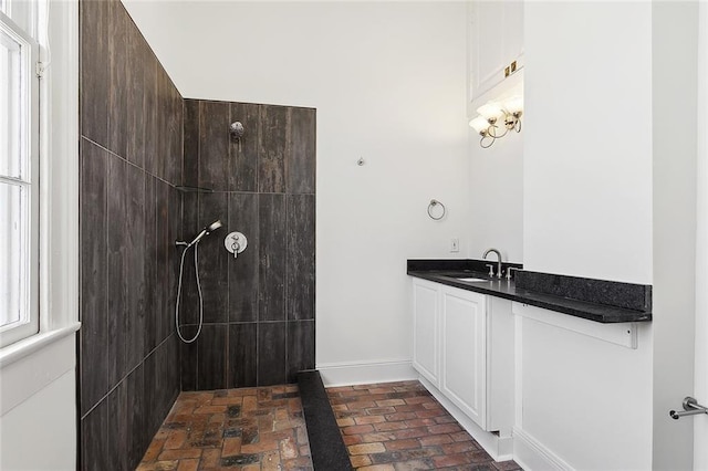 530 Spain St, New Orleans, LA 70117 - bathroom featuring brick floors, a walk in shower, baseboards, and vanity