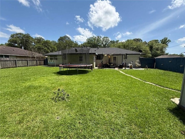9425 Dancy Ave, Baton Rouge, LA 70814 - back of property featuring a trampoline and a patio