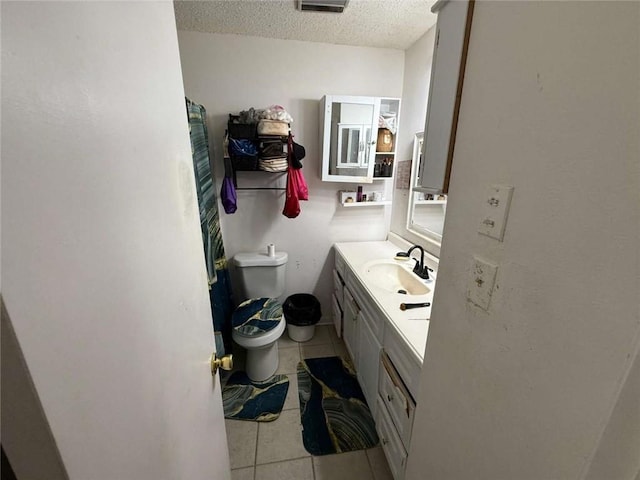 9425 Dancy Ave, Baton Rouge, LA 70814 - bathroom featuring toilet, a textured ceiling, tile patterned flooring, and vanity