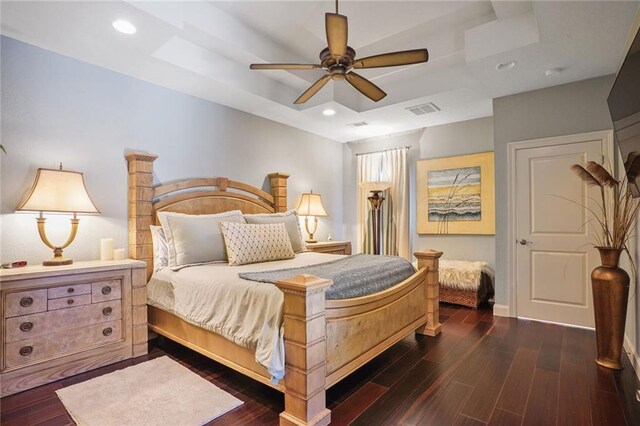 bedroom featuring a raised ceiling, dark wood finished floors, baseboards, recessed lighting, and a ceiling fan