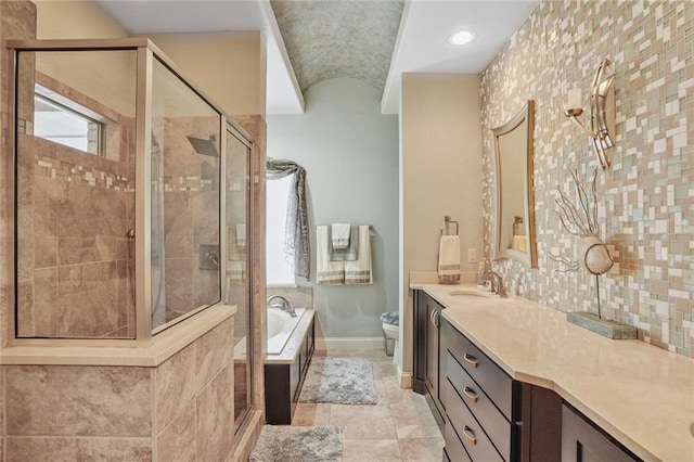 bathroom with a shower stall, toilet, a bath, vanity, and baseboards