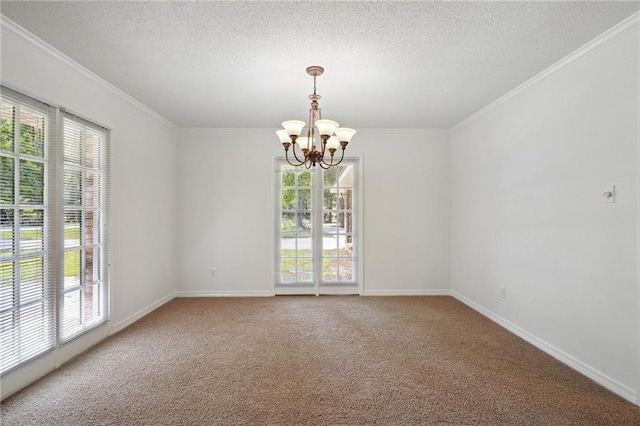 spare room with a chandelier, a textured ceiling, carpet floors, ornamental molding, and baseboards