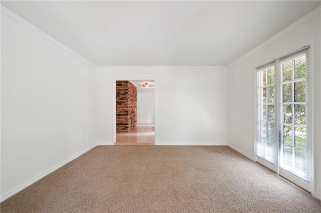 spare room featuring light colored carpet, ornamental molding, and baseboards