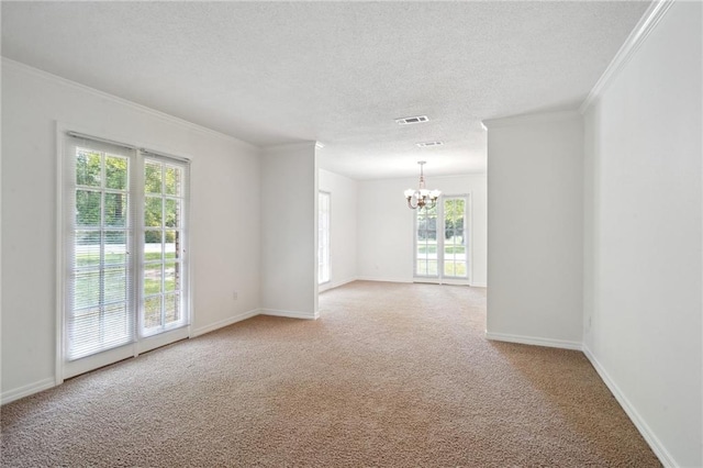 unfurnished room with a chandelier, carpet floors, ornamental molding, a textured ceiling, and baseboards