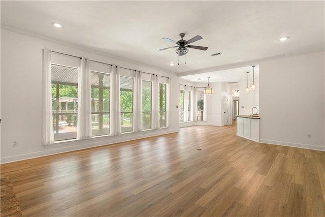 125 Bent Tree Ct, Covington, LA 70433 - unfurnished living room featuring a ceiling fan, crown molding, a sink, light wood-style flooring, and baseboards