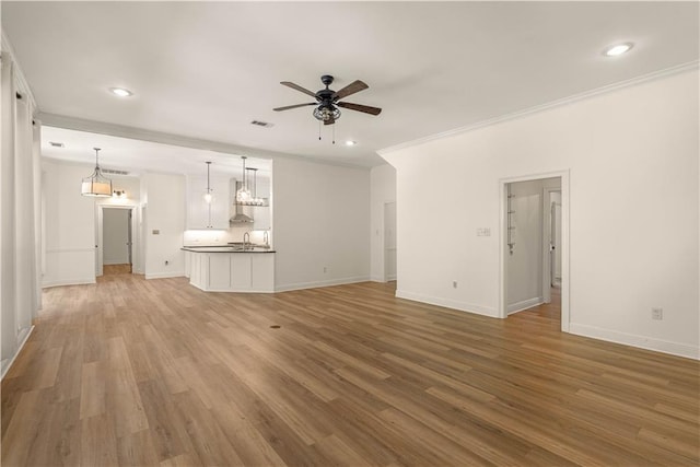 125 Bent Tree Ct, Covington, LA 70433 - unfurnished living room featuring ornamental molding, ceiling fan, a sink, baseboards, and light wood-style flooring