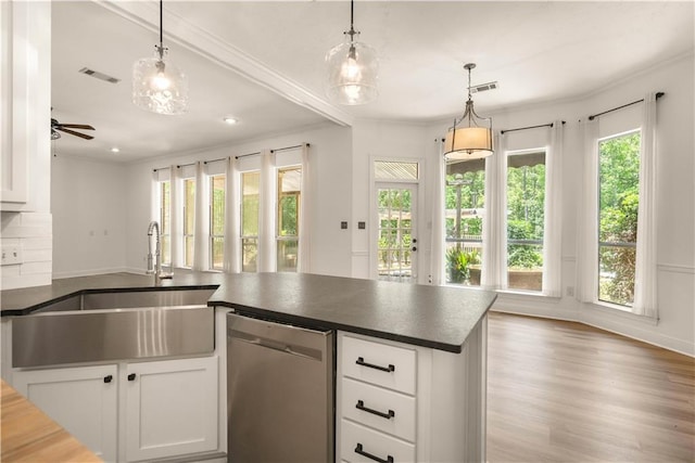 125 Bent Tree Ct, Covington, LA 70433 - kitchen featuring dishwasher, a sink, dark countertops, ornamental molding, and white cabinetry