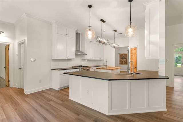 125 Bent Tree Ct, Covington, LA 70433 - kitchen with wall chimney exhaust hood, a sink, dark countertops, wood finished floors, and backsplash
