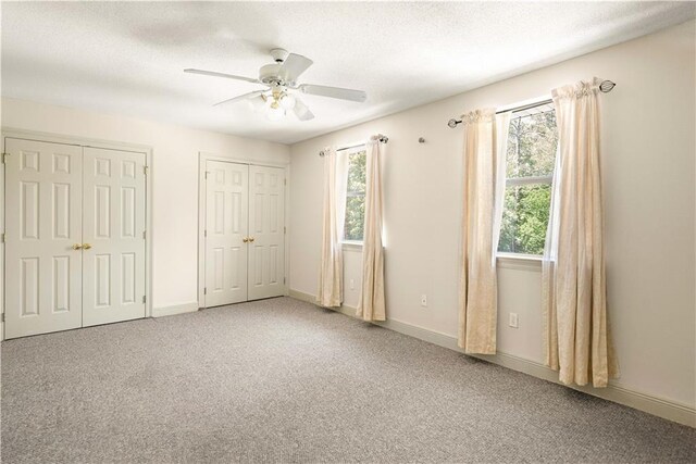 125 Bent Tree Ct, Covington, LA 70433 - unfurnished bedroom with two closets, carpet, a ceiling fan, and baseboards