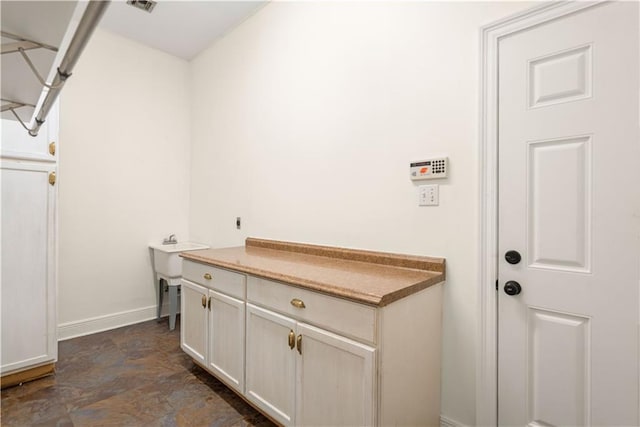 125 Bent Tree Ct, Covington, LA 70433 - laundry room featuring stone finish floors and baseboards