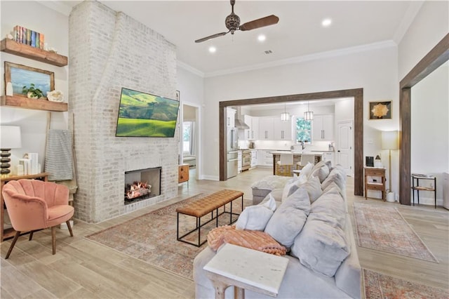 343 Saw Grass Loop, Covington, LA 70435 - living area featuring a ceiling fan, light wood-style flooring, ornamental molding, a fireplace, and recessed lighting
