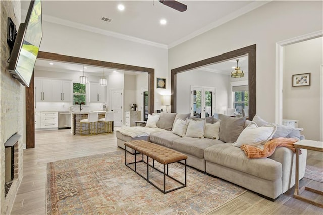 343 Saw Grass Loop, Covington, LA 70435 - living room featuring ornamental molding, light wood-type flooring, a ceiling fan, recessed lighting, and a fireplace