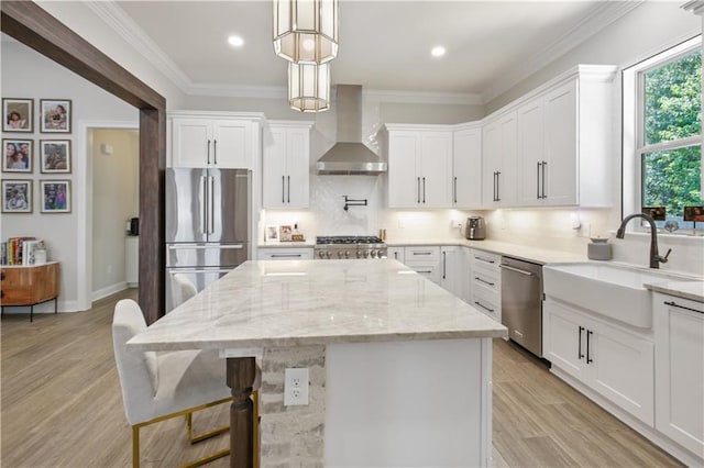 343 Saw Grass Loop, Covington, LA 70435 - kitchen featuring wall chimney exhaust hood, stainless steel appliances, a sink, a kitchen island, and white cabinetry