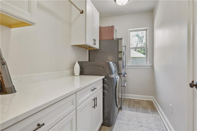 343 Saw Grass Loop, Covington, LA 70435 - clothes washing area with cabinet space, independent washer and dryer, light wood-type flooring, and baseboards