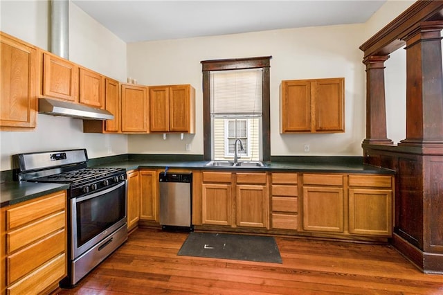 1705-07 Rousselin St, New Orleans, LA 70119 - kitchen featuring stainless steel appliances, a sink, under cabinet range hood, dark wood-style flooring, and dark countertops