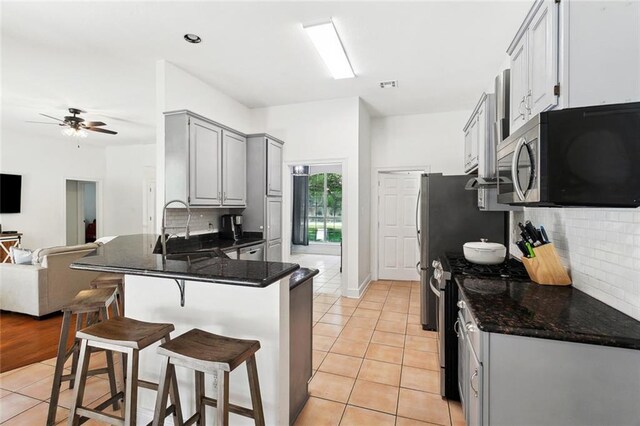 2107 Olvey Dr, Mandeville, LA 70448 - kitchen featuring appliances with stainless steel finishes, a sink, gray cabinets, open floor plan, and tasteful backsplash