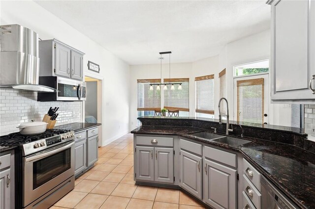2107 Olvey Dr, Mandeville, LA 70448 - kitchen with stainless steel appliances, gray cabinetry, a sink, wall chimney exhaust hood, and tasteful backsplash