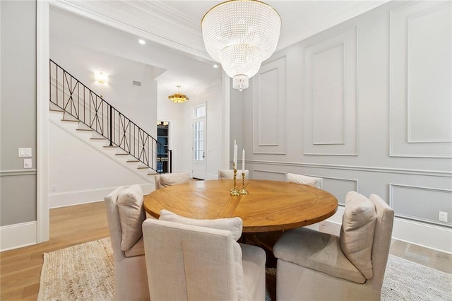 204 Vincent Ave, Metairie, LA 70005 - dining area featuring a chandelier, stairs, light wood-type flooring, crown molding, and baseboards