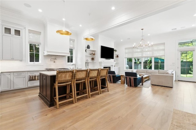 204 Vincent Ave, Metairie, LA 70005 - kitchen with light wood finished floors, light countertops, a breakfast bar, a kitchen island with sink, and recessed lighting