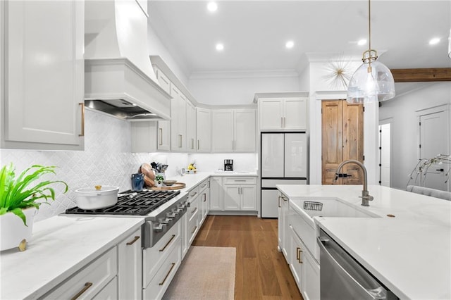 5072 Twin River Pl, Covington, LA 70433 - kitchen featuring custom range hood, stainless steel appliances, a sink, ornamental molding, and dark wood-style floors