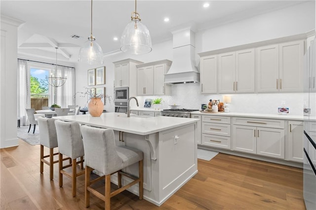 5072 Twin River Pl, Covington, LA 70433 - kitchen featuring custom exhaust hood, recessed lighting, stainless steel appliances, a sink, and a kitchen bar