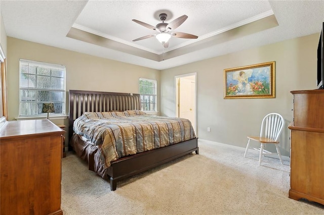 bedroom with a raised ceiling, light carpet, crown molding, a textured ceiling, and baseboards