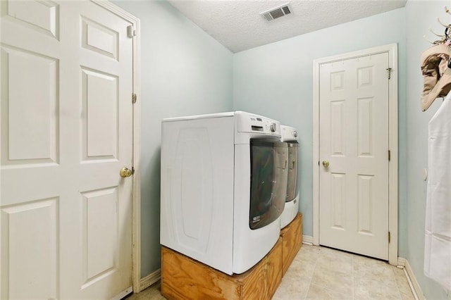 washroom with washer / clothes dryer, a textured ceiling, and baseboards