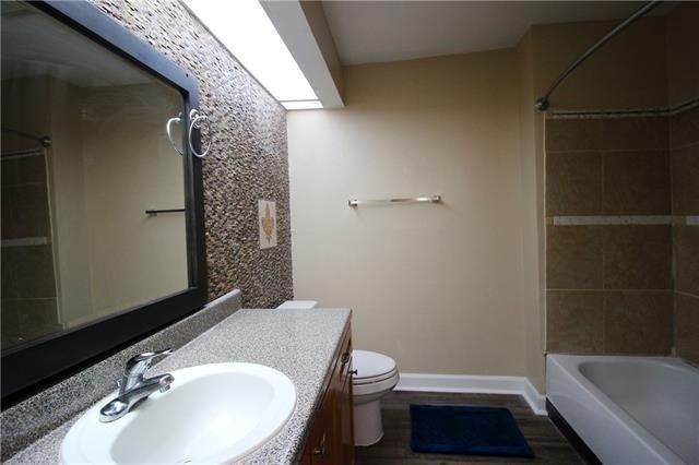 1580 Harbor Dr Unit 127, Slidell, LA 70458 - bathroom with toilet, baseboards, vanity, wood finished floors, and bathtub / shower combination
