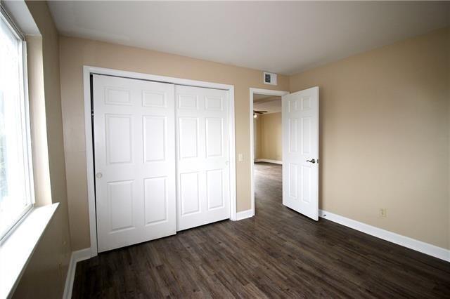 1580 Harbor Dr Unit 127, Slidell, LA 70458 - unfurnished bedroom featuring dark wood-style flooring, baseboards, and a closet