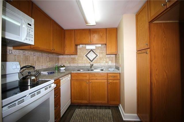 1580 Harbor Dr Unit 127, Slidell, LA 70458 - kitchen featuring white appliances, a sink, dark wood-style flooring, decorative backsplash, and light countertops