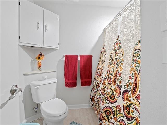 68 Avant Garde Cir Unit 68, Kenner, LA 70065 - full bathroom featuring baseboards, toilet, wood finished floors, and a shower with curtain