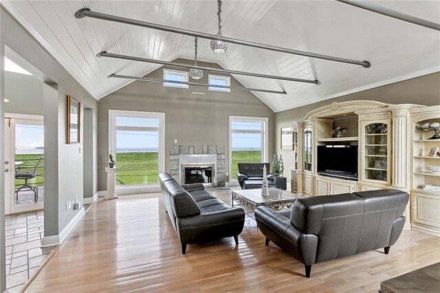 68 Verde St, Kenner, LA 70065 - living room featuring light wood-style floors, vaulted ceiling, a glass covered fireplace, and baseboards
