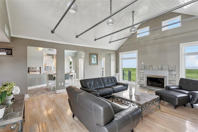 68 Verde St, Kenner, LA 70065 - living room featuring light wood finished floors, a stone fireplace, baseboards, high vaulted ceiling, and wood ceiling